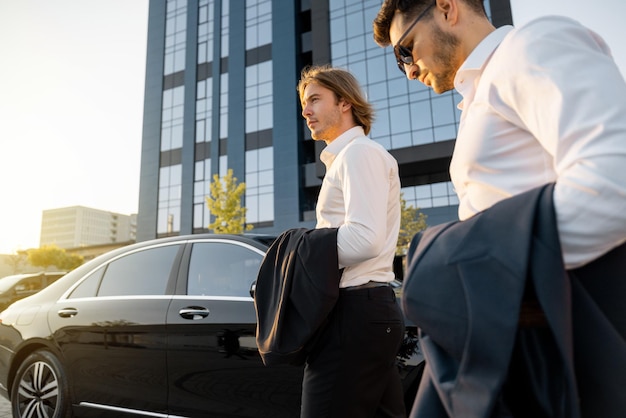 Foto due uomini d'affari che vanno in macchina dopo il lavoro.