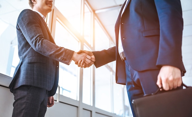 The two businessmen greeting in the office hall