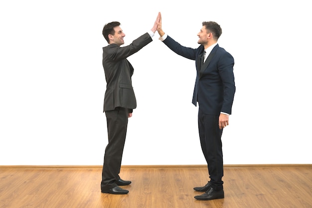 The two businessmen greeting on the white wall background