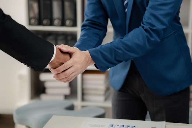 Photo two businessmen holding hands two businessmen are agreeing on business together and shaking hands after a successful negotiation handshaking is a western greeting or congratulation