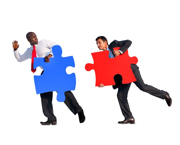 Photo two businessmen holding jigsaw puzzles in a white background