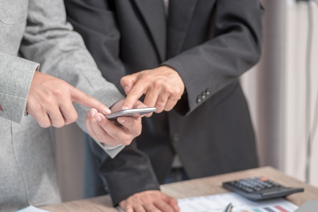 Two businessmen look at mobile