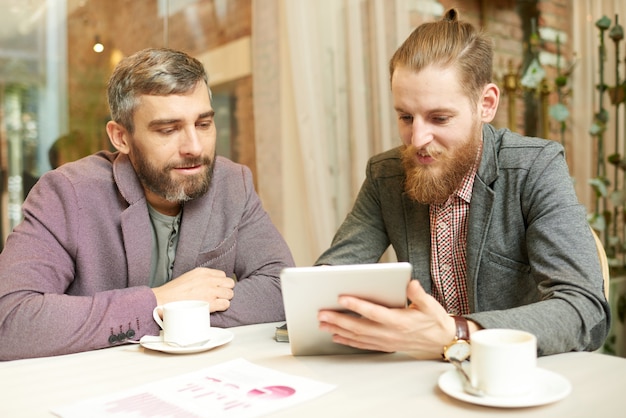 Two Businessmen Meeting at Coffee Break in Cafe