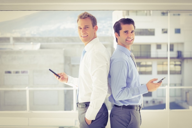 Two businessmen standing back to back 