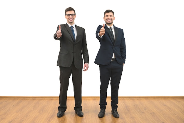 The two businessmen thumb up on the white wall background