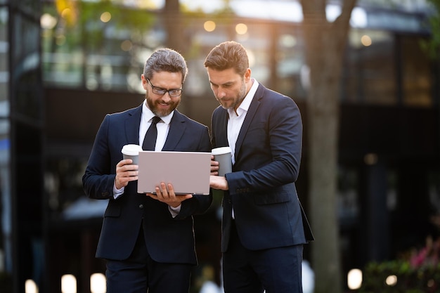 Two businessmen trading online copy space businessmen trading online outdoor businessmen trading online with laptop photo of businessmen trading online