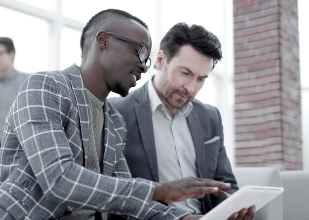 Two businessmen use a digital tablet