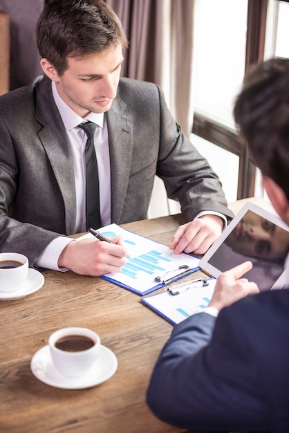 Two businessmen working during a business lunch.