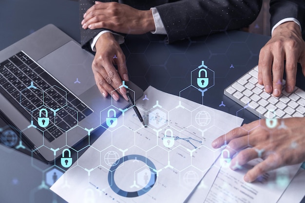 Two businesspeople man and woman working on the project to protect cyber security of international company Padlock Hologram icons over the table with documents Formal wear Workspace