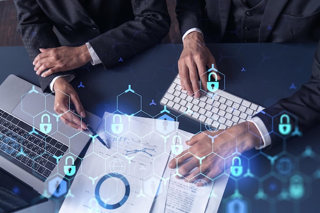 Two businesspeople man and woman working on the project to protect cyber security of international company Padlock Hologram icons over the table with documents Formal wear Workspace