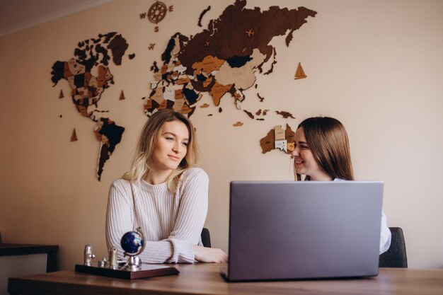 Photo two businesswomen employees colleagues discussing working together on business project using laptop female executive explaining new online idea to coworker cooperating analyzing computer software