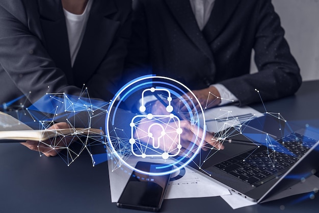 Two businesswomen working on the project to protect cyber
security of international company padlock hologram icons over the
table with documents