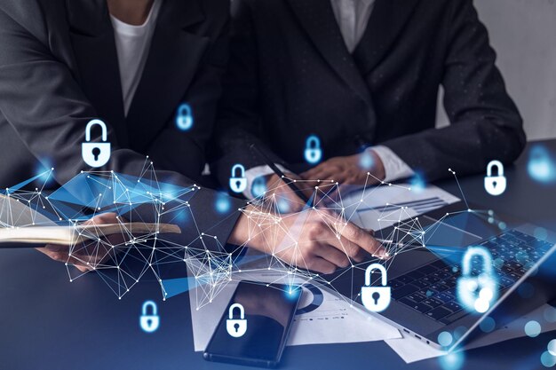 two businesswomen working on the project to protect cyber security of international company padlock hologram icons over the table with documents