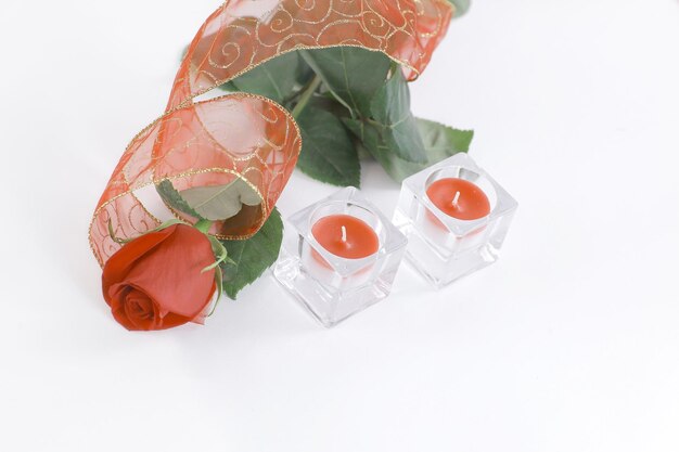 Two candles and a red rose on a white backgroundphoto with copy