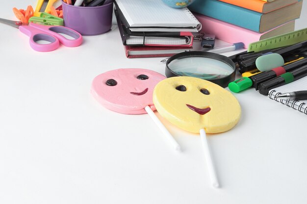 Two candy and school supplies on a white background