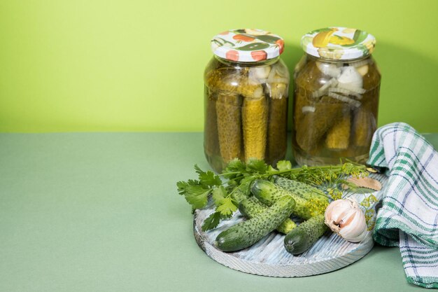 Photo two cans of pickles and gherkins pickled pickles on a round wooden chopping