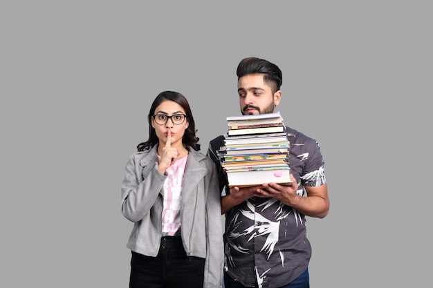 two casual students front pose holding books indian pakistani model