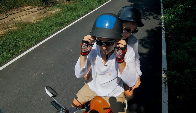 Two caucasian tourist woman man drive on red scooter Make it selfie Love couple on motorbike