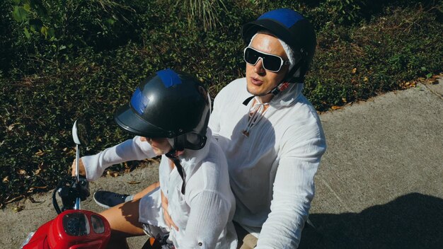 Two caucasian tourist woman man drive on red scooter Make it selfie Love couple on motorbike