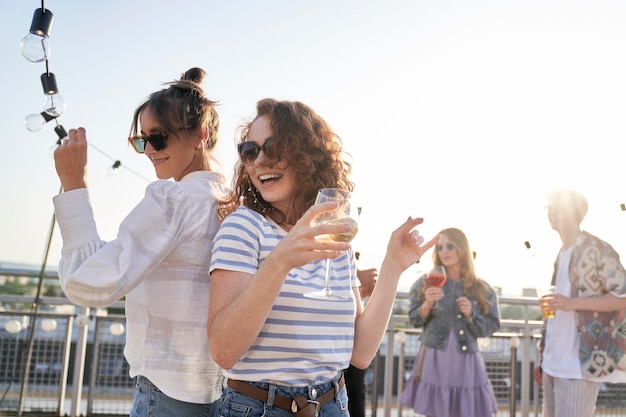 Two caucasian women dancing at the rooftop in summer day