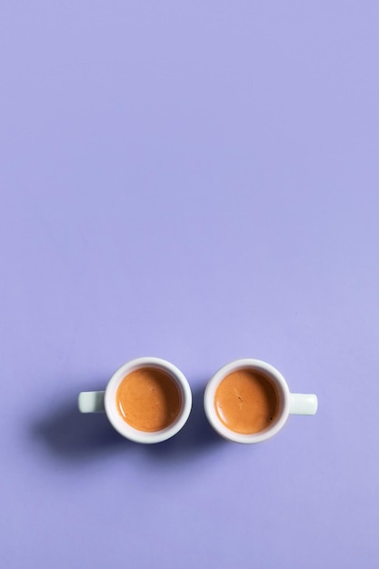 Two ceramic cups of espresso coffee Top view Minimalistic vertical stock photo in very peri color