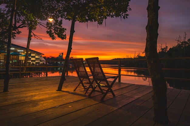 two chairs by the wain river at romantic sunset