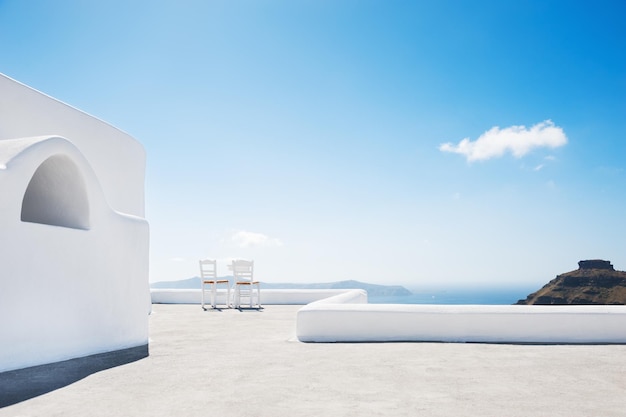 Due sedie in terrazza con vista mare. architettura bianca sull'isola di santorini, grecia.