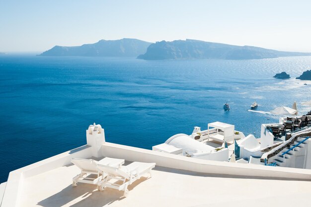 Two chaise lounge on the terrace. Santorini island, Greece. Travel and vacation