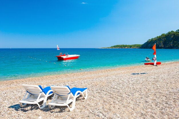 Foto due lettini sulla spiaggia ghiaiosa di kemer, turchia. bellissimo paesaggio estivo