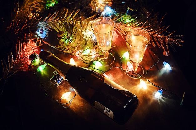 Two champagne glasses and Christmas ornaments. Romantic evening with drinking alcohol. The celebration of new year and Christmas. Happy holiday.