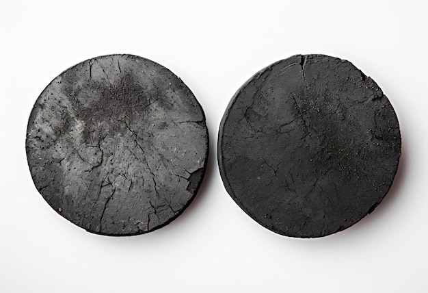 two charcoal tablets on a white background