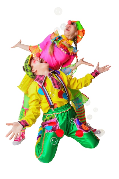 Two cheerful clowns joy in the soap bubbles isolated on the white background