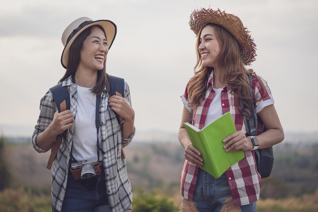 Two cheerful female traveller in countryside