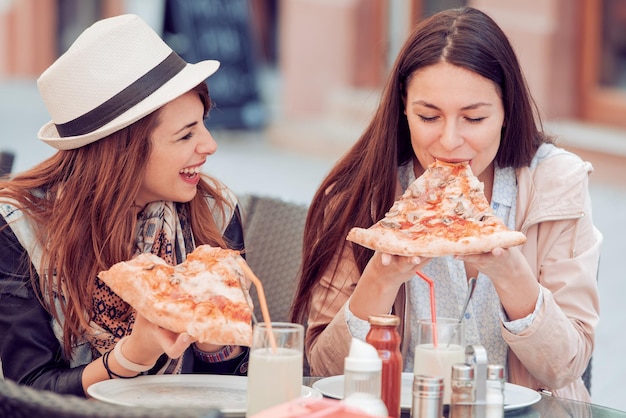 ピザを食べる 2 人の陽気な女の子