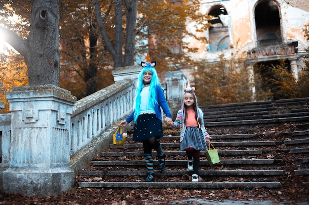 Two cheerful little girls, in colorful halloween costume of unicorn