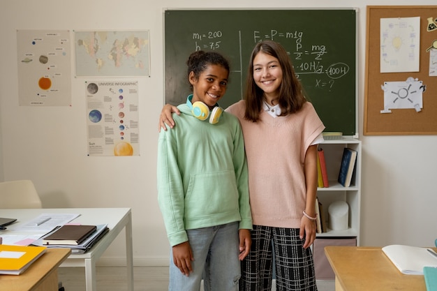 Two cheerful multiracial schoolgirls in casualwear