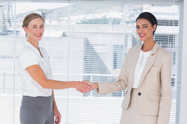 Two cheerful partners shaking hands