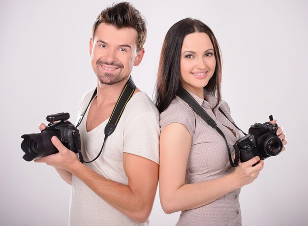 Two cheerful photographers holding cameras.