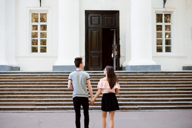 Two cheerful students in love heading to the university in the morning