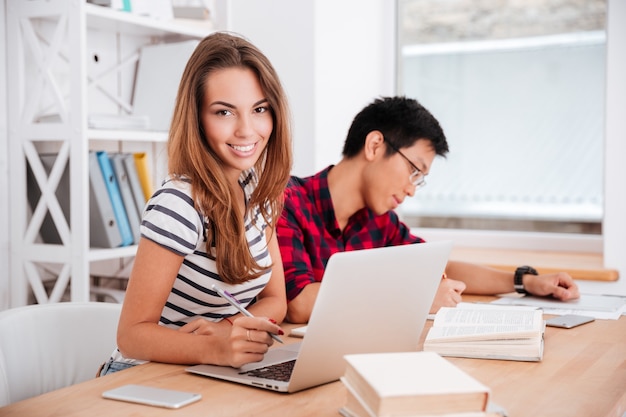 Two cheerful students working on a project together