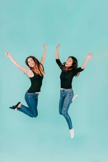 Two cheerful women jumping high