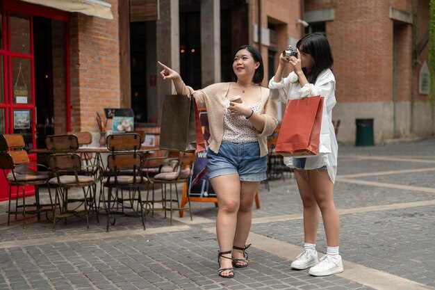 Two cheerful young Asian women girlfriends are enjoying their weekend in the city together