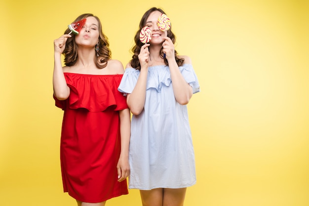 two cheerful young women posing with sweets