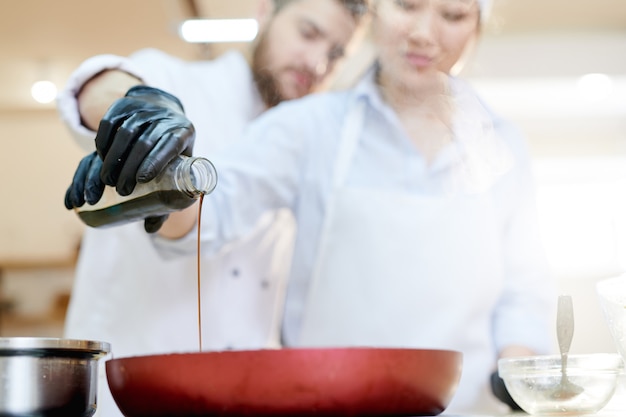 Foto salsa di soia di versamento di due cuochi unici