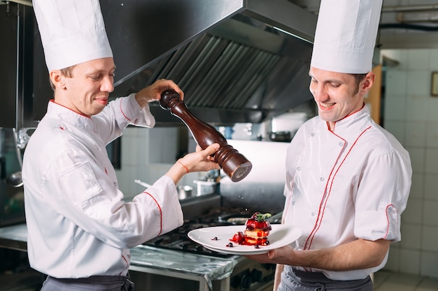 Two Chefs Sha background kitchen pepper dishes.