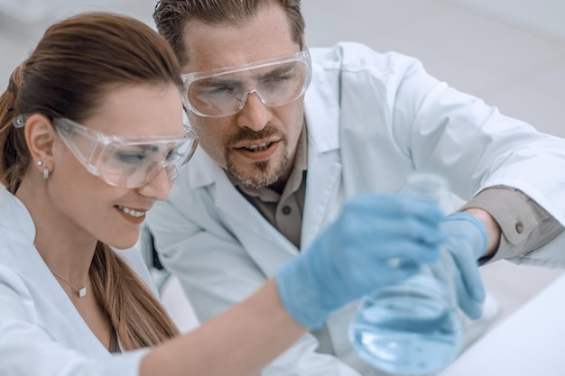 Two chemists working with different liquids in tubes