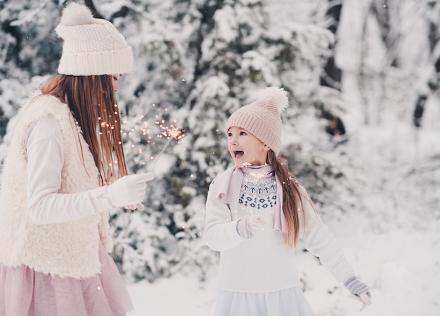 Two child girls having fun in snow outdoors