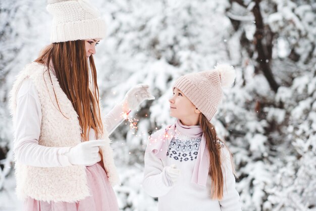 Two child girls having fun in snow outdoors