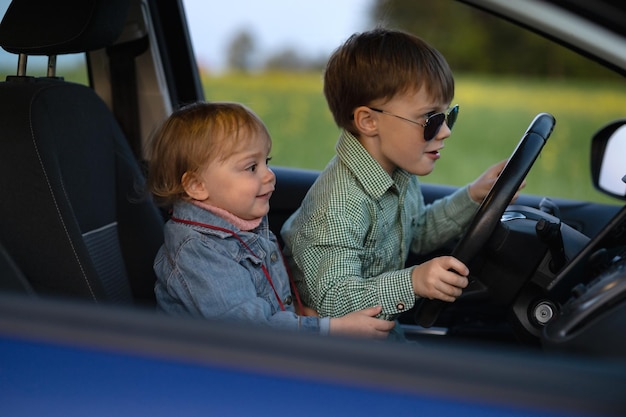 두 아이가 차를 운전하고 있다