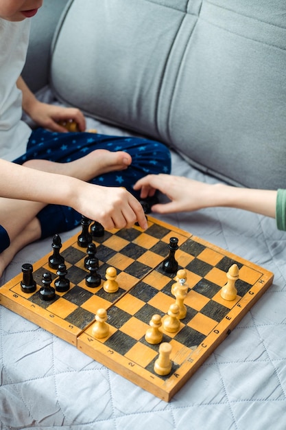 Two children are playing chess closeup Makes a knight and pawn move